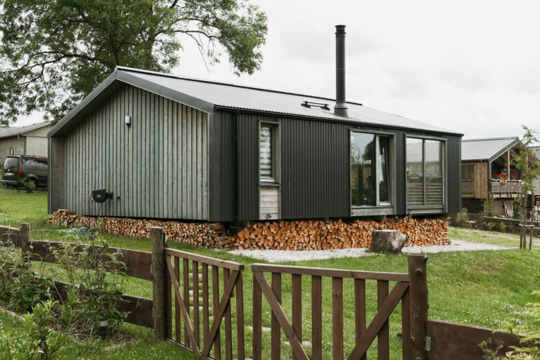 Modern cabin exterior with woodpile at Bohemian Homes, Bohemian Switzerland, Czech Republic.