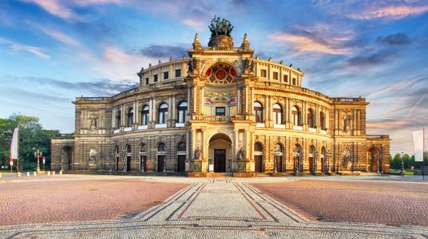 Historic building with intricate architecture and cobblestone plaza.
